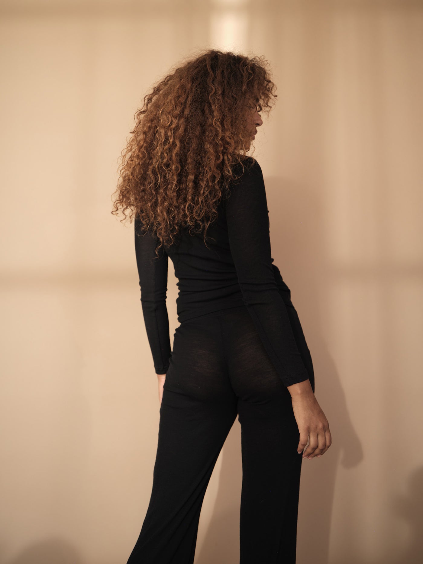 Female wearing our Amalie Wool Pants. Seen from the back. 